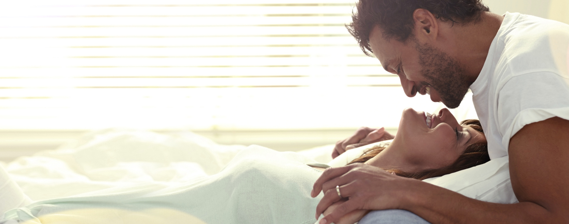 Imagen de un hombre y una mujer en la cama sonriendo